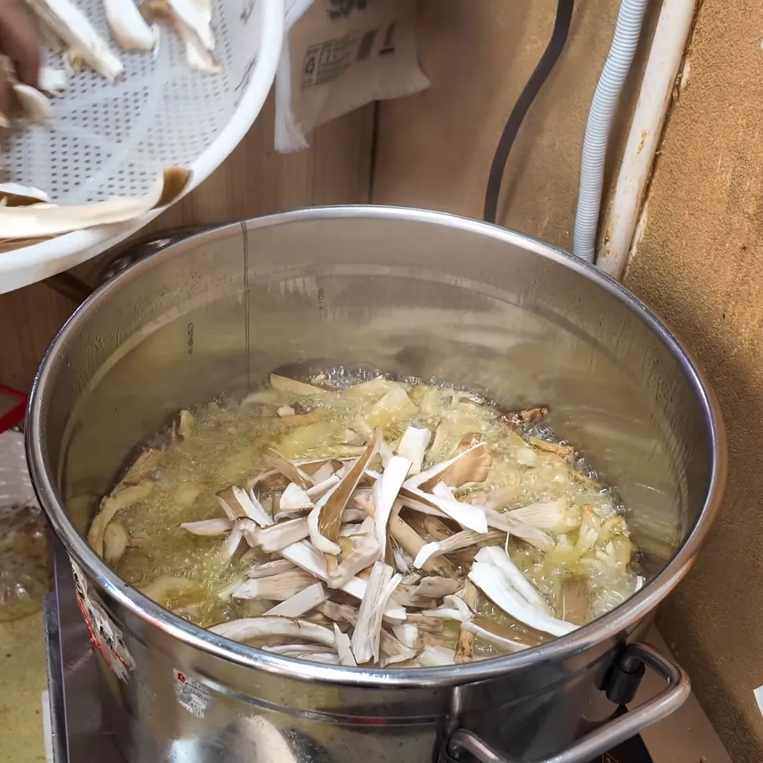 Sliced wild mushrooms going into a hot wok
